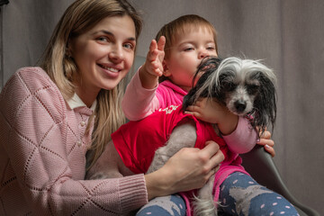 A beautiful young mother with a little daughter is photographed in a home studio.