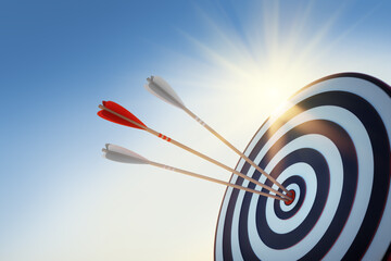 Archery target with hits by three arrows with sun and sky with sun flares - obrazy, fototapety, plakaty