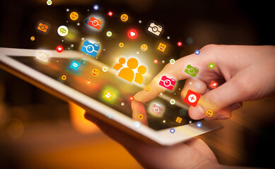 Close-up of a hand using tablet with social media icons