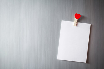 Abstract of wooden heart clip with Blank paper and stick paper on refrigerator door. paper note copy space for add text. valentine picture message background