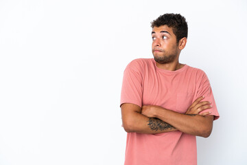 Young handsome Brazilian man isolated on white background making doubts gesture while lifting the shoulders