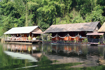 Obraz premium Boote und Häuse am Ufer des River Kwai, Katchanaburi, Thailand