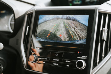 car rear view system monitor reverse video camera screen. modern digital technology equipment on automobile dash for safety drive travel. traffic on wild rural mud earth road in field or forest - obrazy, fototapety, plakaty