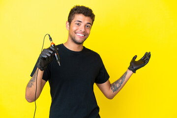 Tattoo artist Brazilian man isolated on yellow background extending hands to the side for inviting to come
