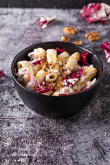 Creamy pasta with ricotta, walnuts and radish. Vegetarian macaroni pasta with ricotta and radicchio.