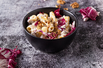 Creamy pasta with ricotta, walnuts and radish. Vegetarian macaroni pasta with ricotta and radicchio.