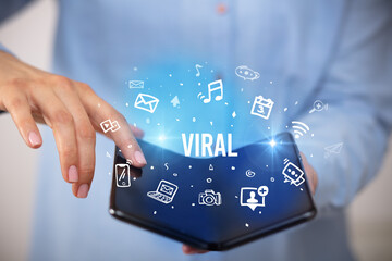 Businessman holding a foldable smartphone, social media concept