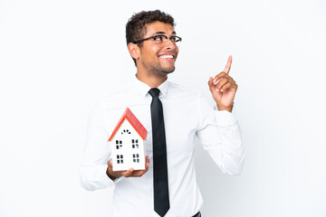 Young business Brazilian man holding a house toy isolated on white background pointing up a great idea