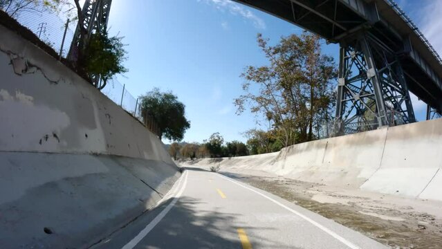 Rear riding view of the Arroyo Seco Bike Path and railroad bridge in the Highland Park neighborhood of Los Angeles California.