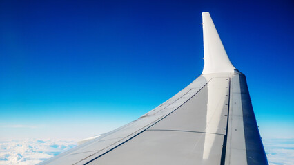 Boeing 737 MAX 8 White Wing Over White Air Clouds And Clear Blue Sky. - obrazy, fototapety, plakaty