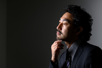 Middle-aged Asian man in a suit that could be used for a bearded beauty or management image. - obrazy, fototapety, plakaty