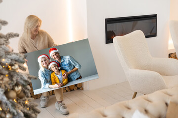 woman holding a photo canvas as a Christmas present