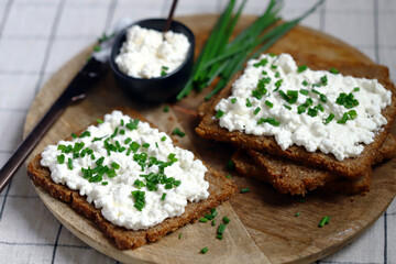 Open sandwiches with rye bread and white cottage cheese with green onions. Healthy breakfast or snack.