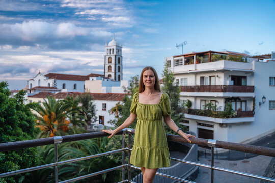 Landscape with Garachico town of Tenerife, Canary Islands, Spain. Happy carefree light airy multiracial girl smiling. Young woman in dress enjoying vacation. Travel concept.