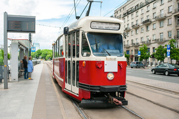 Fototapeta na wymiar Beautiful tram on railroad near building outdoors