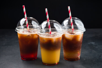 Various iced layered coffee drinks with orange juice and syrups