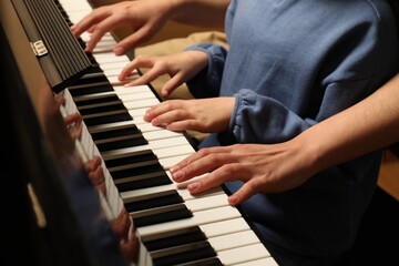 Young woman with child playing piano, closeup. Music lesson