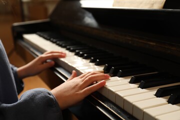 Fototapeta premium Little child playing piano, closeup. Music lesson