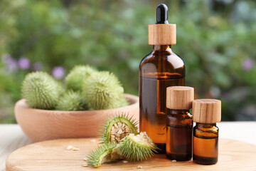 Fototapeta premium Bottles of essential oil and thorn apple on white wooden table. Space for text