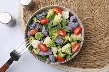 Delicious salad with cauliflower and tomato served on white table, flat lay