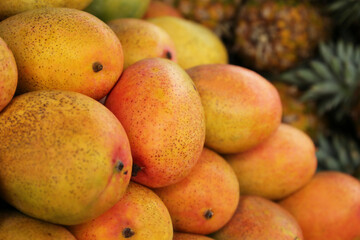 Pile of delicious ripe yellow mangoes, closeup