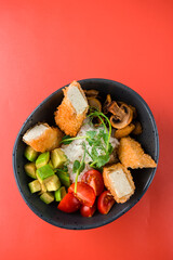 Asian food rice with breaded tofu cheese, champignons, avocado, cherry tomatoes, decorated with green peas.