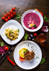 three-course set on a table. Tasty lunch set made of three meals, such as soup, salad and meat with mashed potato