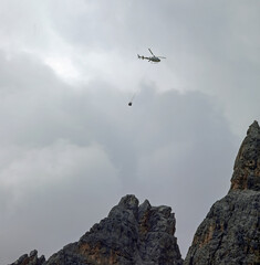 helicopter flying with cargo hanging during the rescue mission