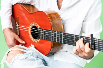 Young man with beard with guitar over isolated chroma key background