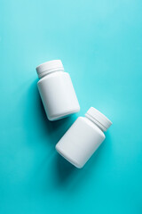 White pill bottles on blue background. Health care food supplements, vitamins and medicaments