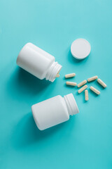 White pill bottles on blue background. Health care food supplements, vitamins and medicaments