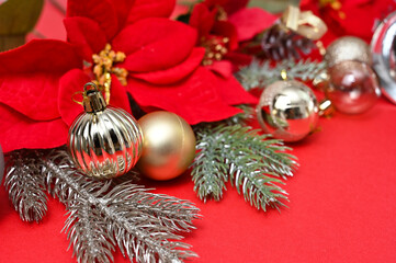 Christmas material, bells and X'mas Flower and ball decorations on a red background.