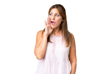 Fototapeta premium Middle age woman over isolated background whispering something with surprise gesture while looking to the side