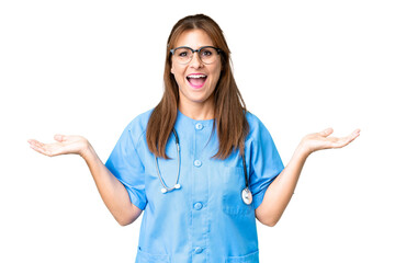 Middle age nurse woman over isolated background with shocked facial expression