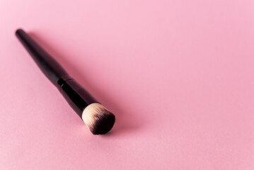 Obraz na płótnie Canvas Black Make-Up Brush on Pink Background Horizontal Copy Space