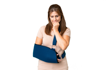 Middle age with broken arm and wearing a sling over isolated background having doubts