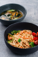 Lunch noodles with salmon and tomatoes and miso soup with tofu cheese, seaweed wakame, onions and shiitake mushrooms.