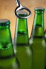 Opening bottle of beer on light brown background, closeup