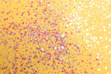 Shiny bright glitter on yellow background, flat lay