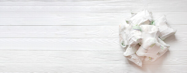 Diapers waste - dirty diapers of baby. Disposing of used baby nappies. used diapers on white wooden background.