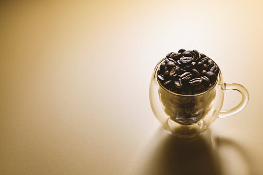 coffee beans in a cup isolated on plain background, backlit photography