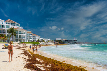 PLAYA DEL CARMEN, MEXICO - APR 2022: Woman in sexy brasilian bikini on a sandy beach near hotel in Playa del Carmen, Mexico