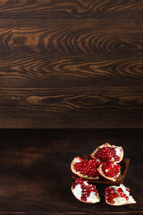Naklejka na ściany i meble ripe peeled pomegranate on a wooden background, pomegranate seeds. with copyspace.