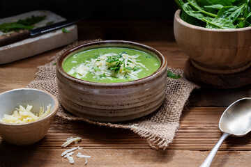 Green creamy spinach soup rustic, lifestyle food, delicious vegan food.