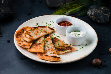 Tortillas with sour cream sauce and tomato salsa.