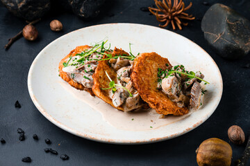 Dinner draniki with beef and mushrooms in a creamy sauce.