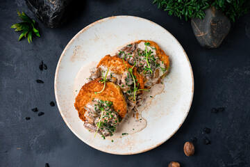 Potato draniki with beef and mushrooms in a creamy sauce.
