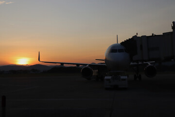 silhouette of plane in the airport against sunset sky background