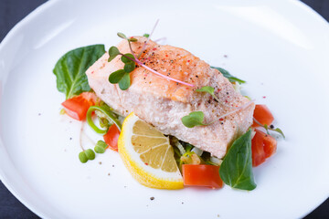 Trout (salmon) with vegetables, lemon and microgreens, cooked by the confit method. Traditional French dish. Step by step. Close-up.