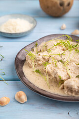 Stewed chicken fillets with coconut milk sauce. side view, selective focus.